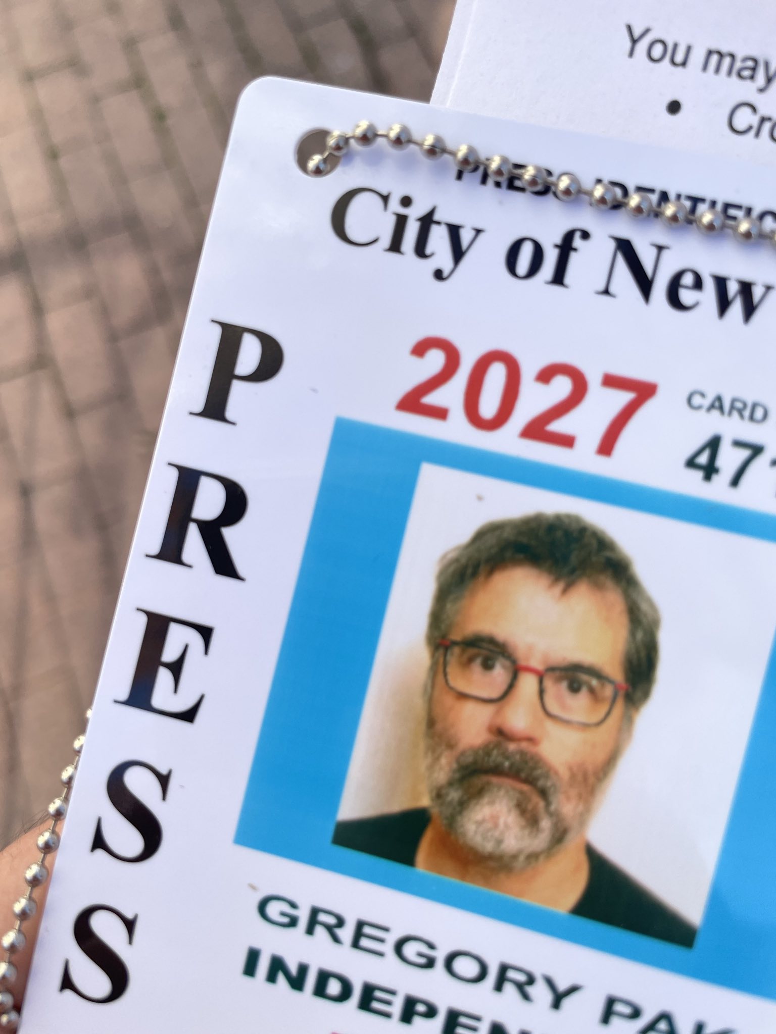 photo of the corner of a City of New York press card for Greg Pak featuring his mugshot, the word PRESS and the date 2027.