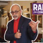 Photo of Chris Rabb gesturing with both hands while speaking. He's been outlined with a hand-drawn white line and a few hand-drawn stars surround him, along with a RABB FOR CONGRESS logo.