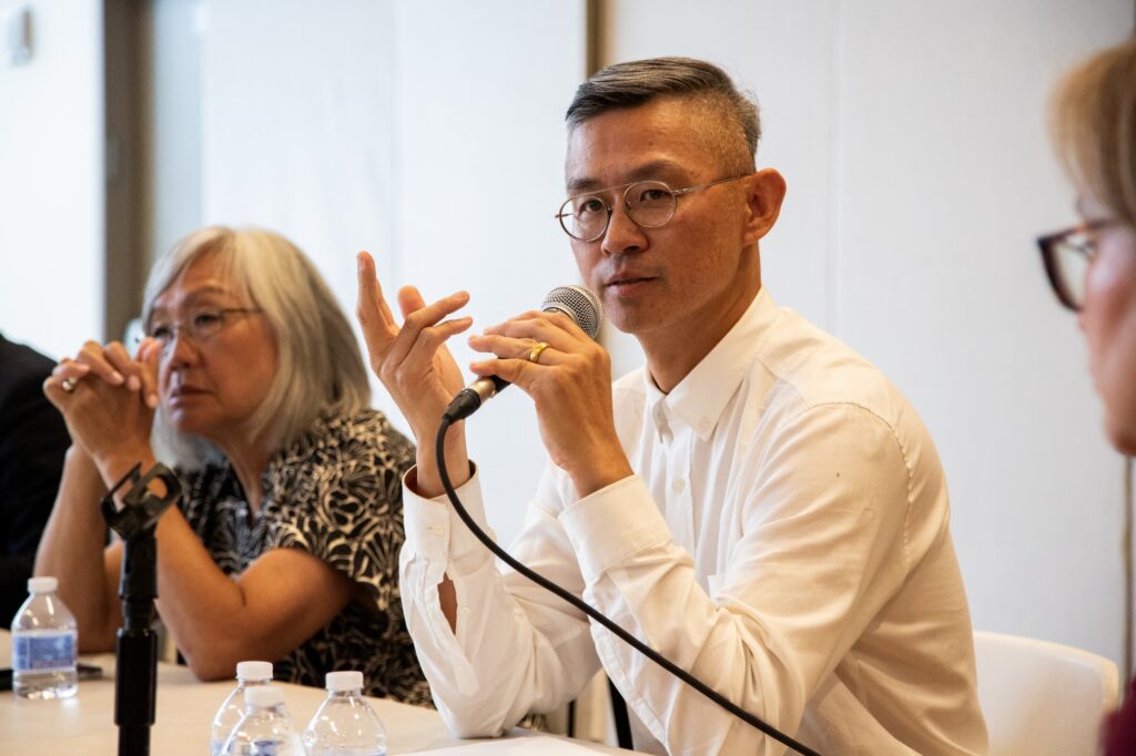MOCA curator Herb Tam speaks into a microphone.