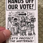 Hand holding a zine titled "HANDS OFF OUR VOTE!" with the subtitle "LET'S PROTECT THE MIDTERMS!" Art by Priya Huq shows a multiracial group of people of various ages standing lined up in front of a "VOTE HERE / VOTE AQUI" sign, smiling, with fists raised.