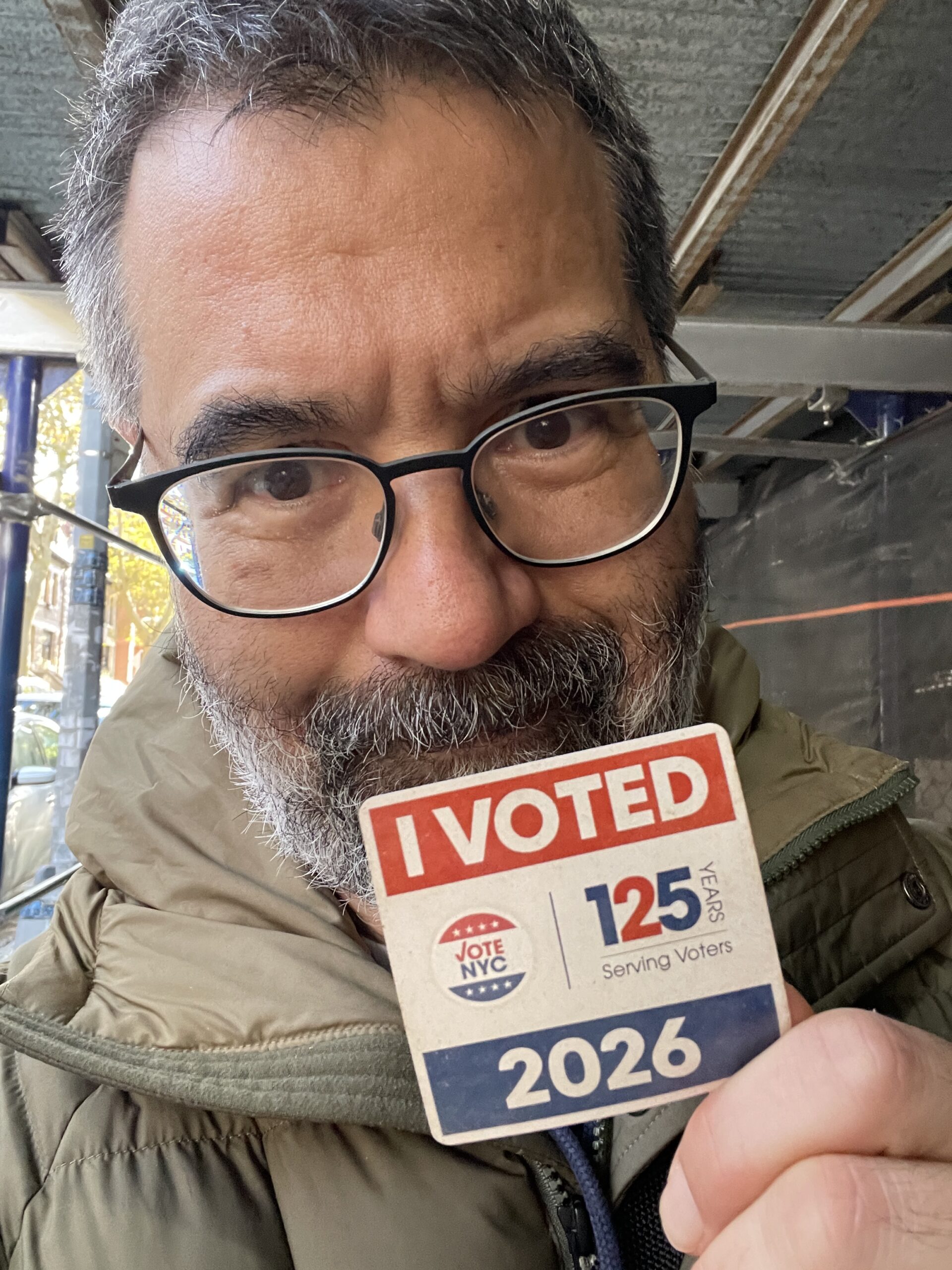 Selfie of Greg Pak smiling and holding up an "I VOTED" sticker